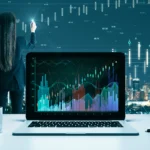 An adult with long dark hair analyzes data on a laptop. The woman is seen from the back, and wears a business suit. She holds a pen to the transparent display, seemingly annotating the data shown.