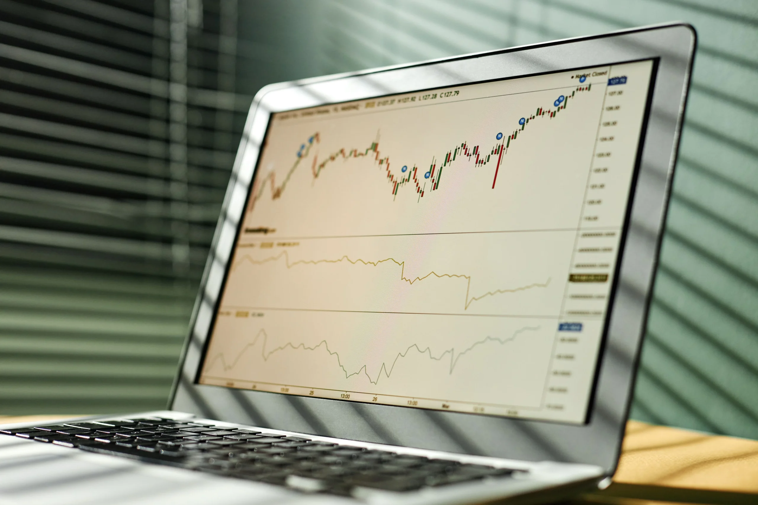 Close-up-of-a-laptop-displaying-stock-market-data-and-graphs-in-an-office-setting