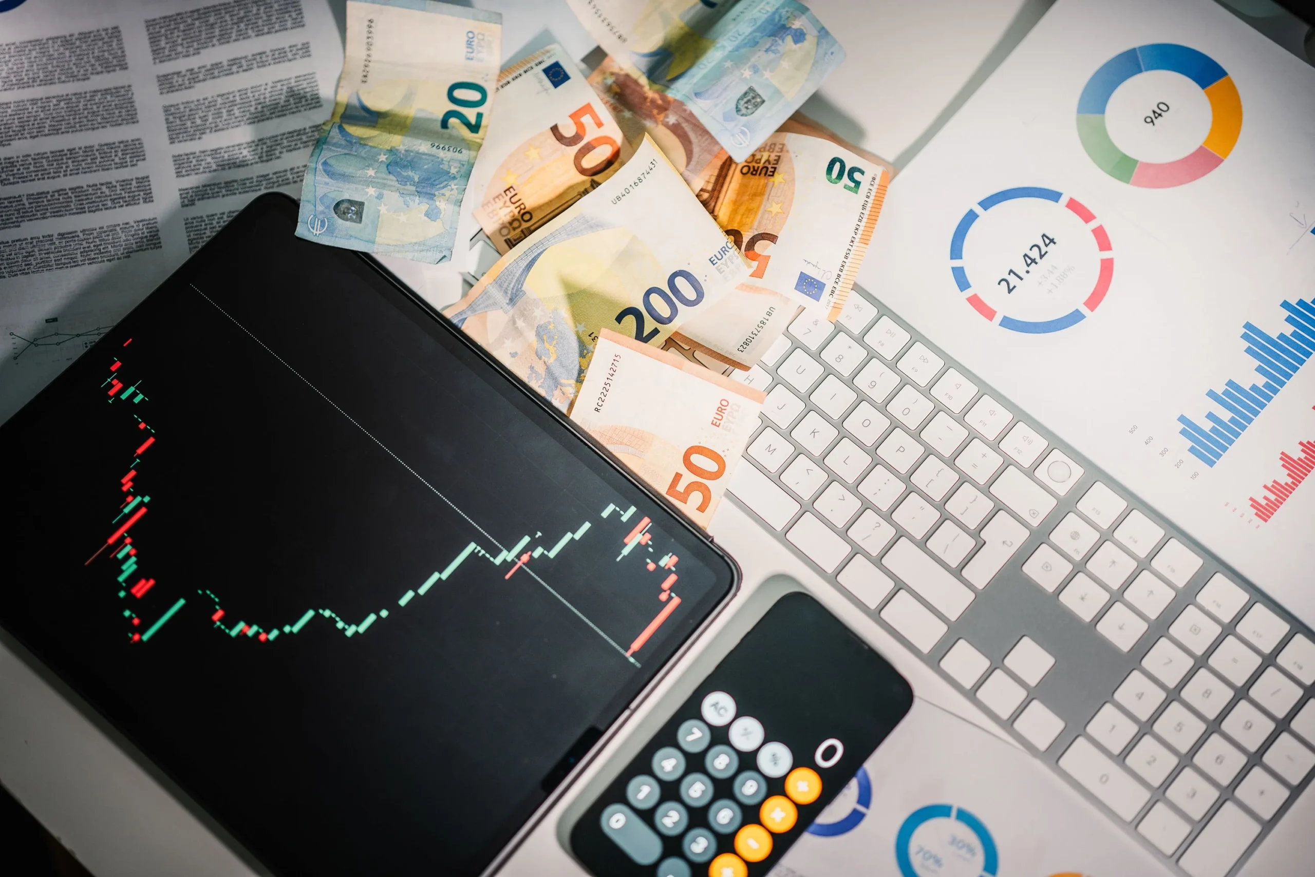 Overhead-view-of-financial-tools-with-Euro-banknotes-on-a-desk-showing-market-trends-and-graphs