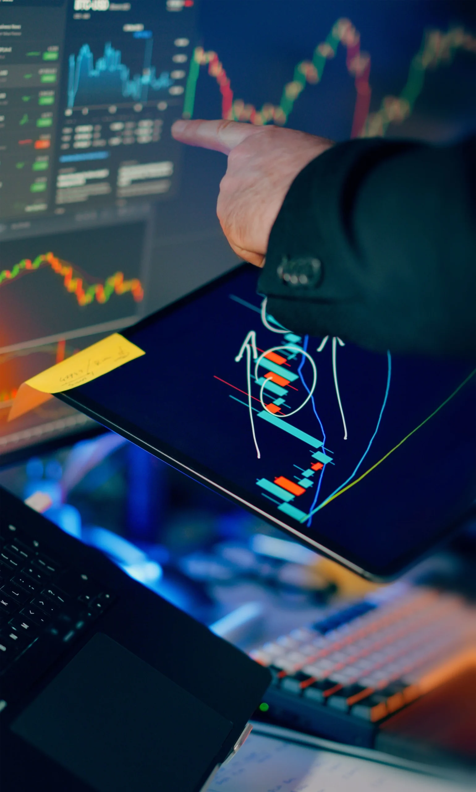 A-business-professional-examines-financial-charts-on-a-tablet-and-monitor-for-investment-strategy